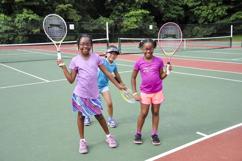 Campers at a tennis camp pose for the camera.