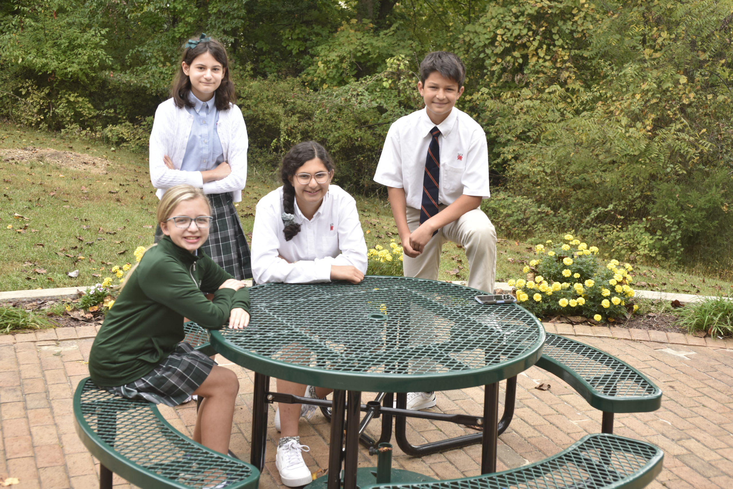 Middle School students Vita Wyatt '27, Nora Blagojevic '27, Ella Madhok '26, and Miles Naga '28 on the divison's patio.