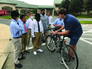 Josef Marschall shows his electronic bike to a group of Middle School students.