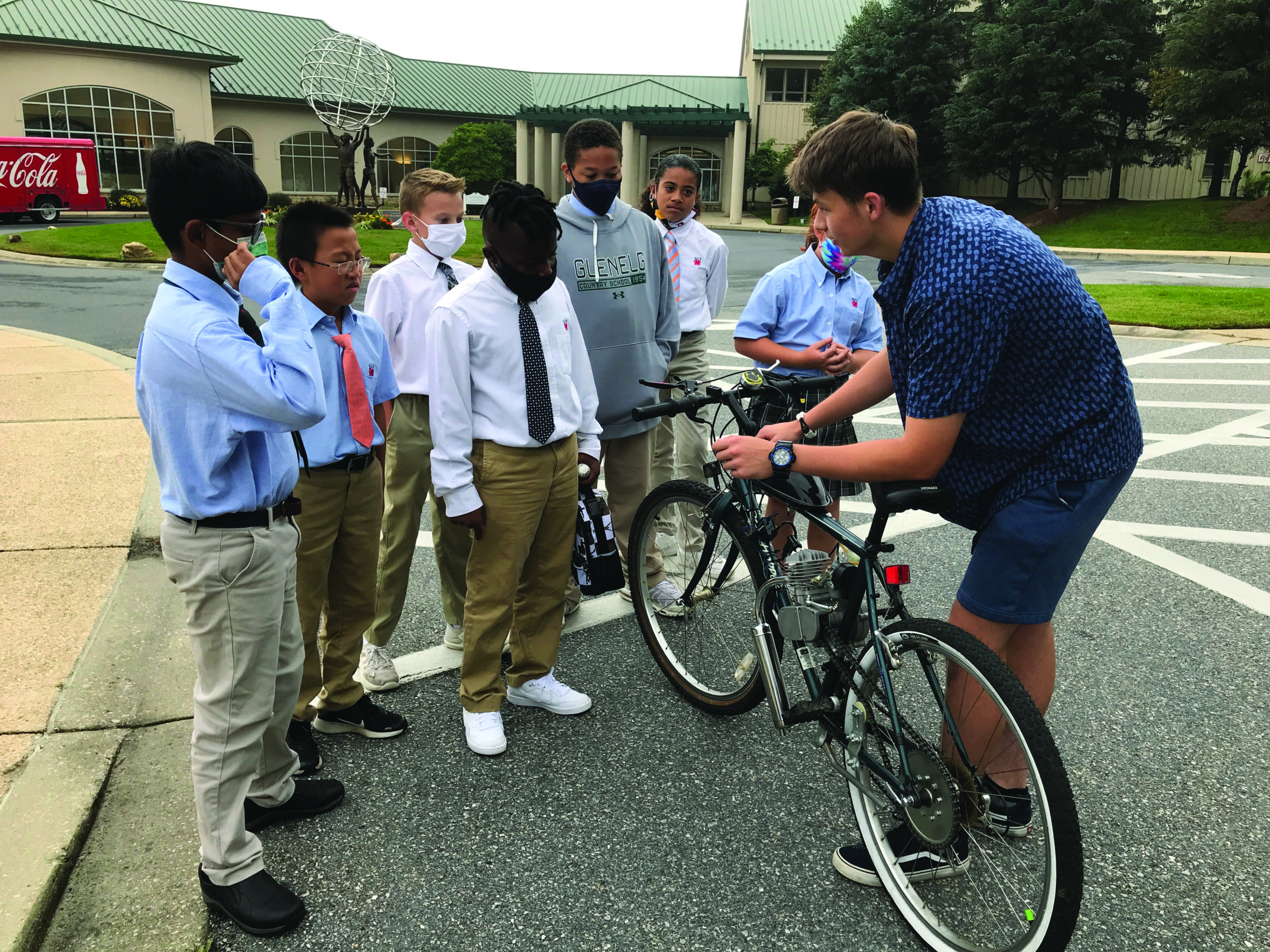 Josef Marschall shows his electronic bike to a group of Middle School students.