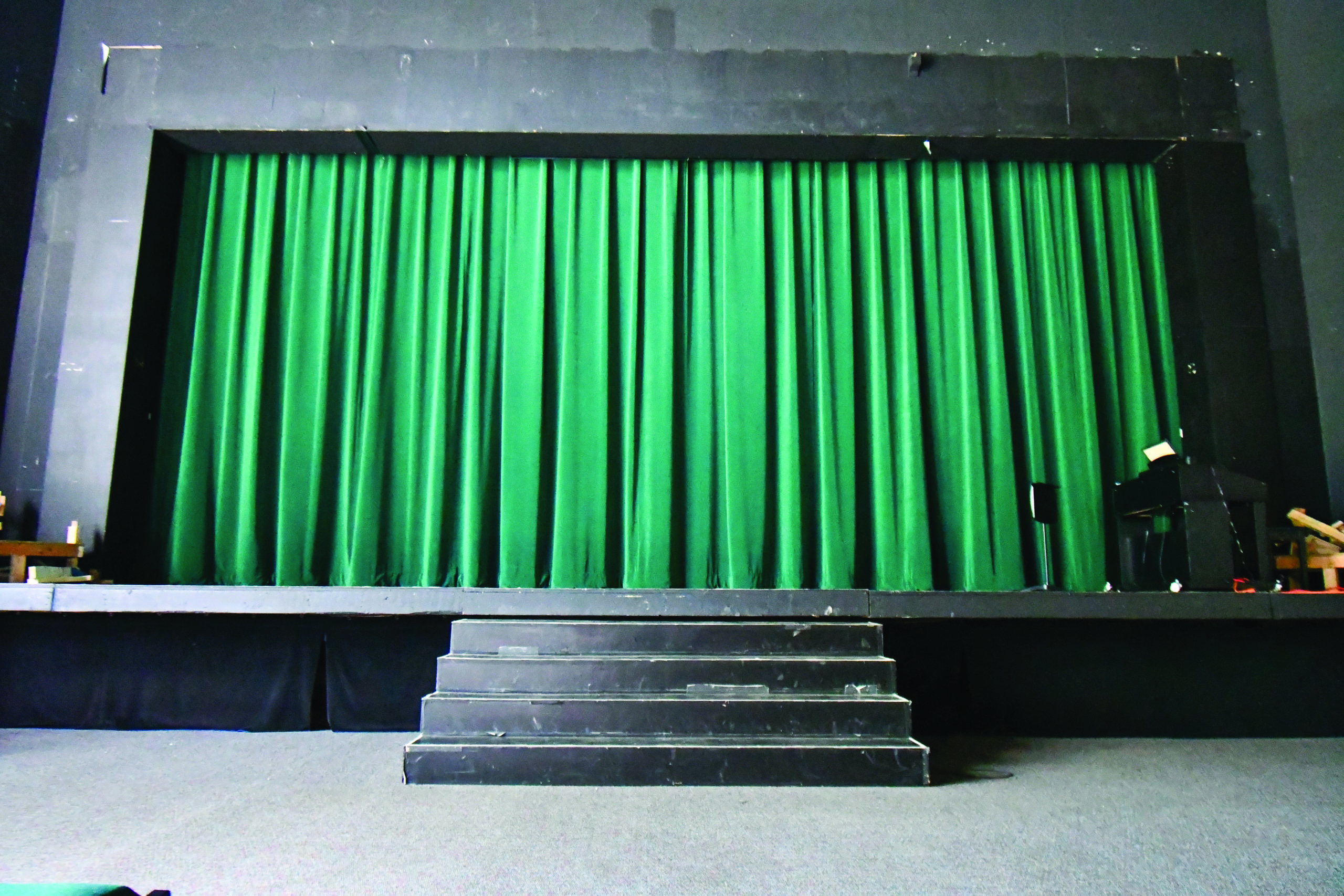 A green curtain hides the stage of Mulitz Theater.