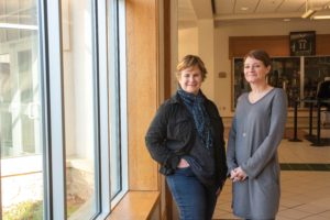 Deborah Banker and Christy Colde stand together in the hallway of the Upper School.