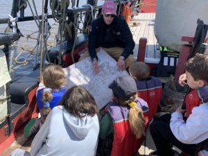 Students learn about chart mapping on a boat.
