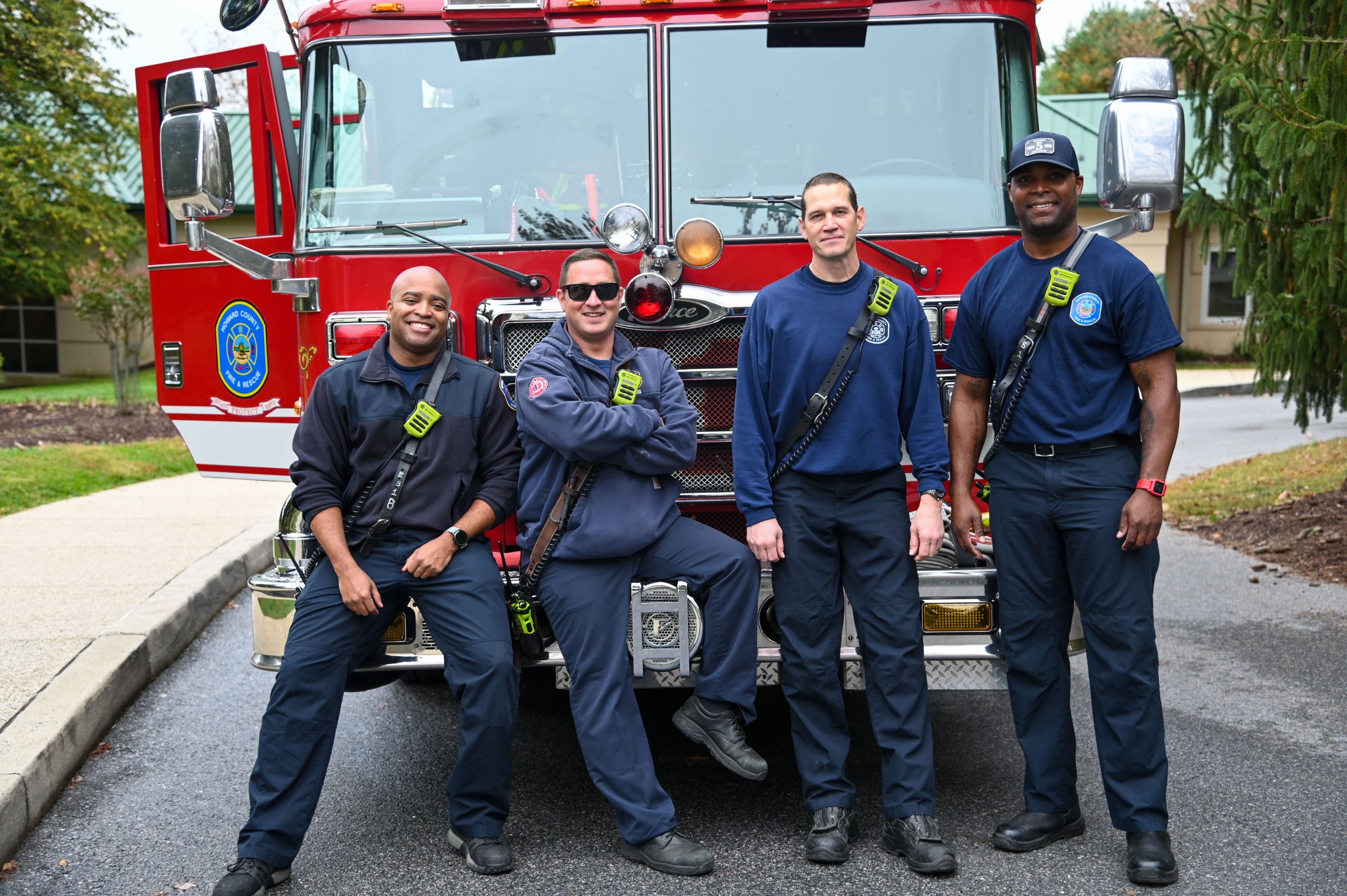 Fire safety experts—volunteer firefighters—stand in front of their fire engine truck.