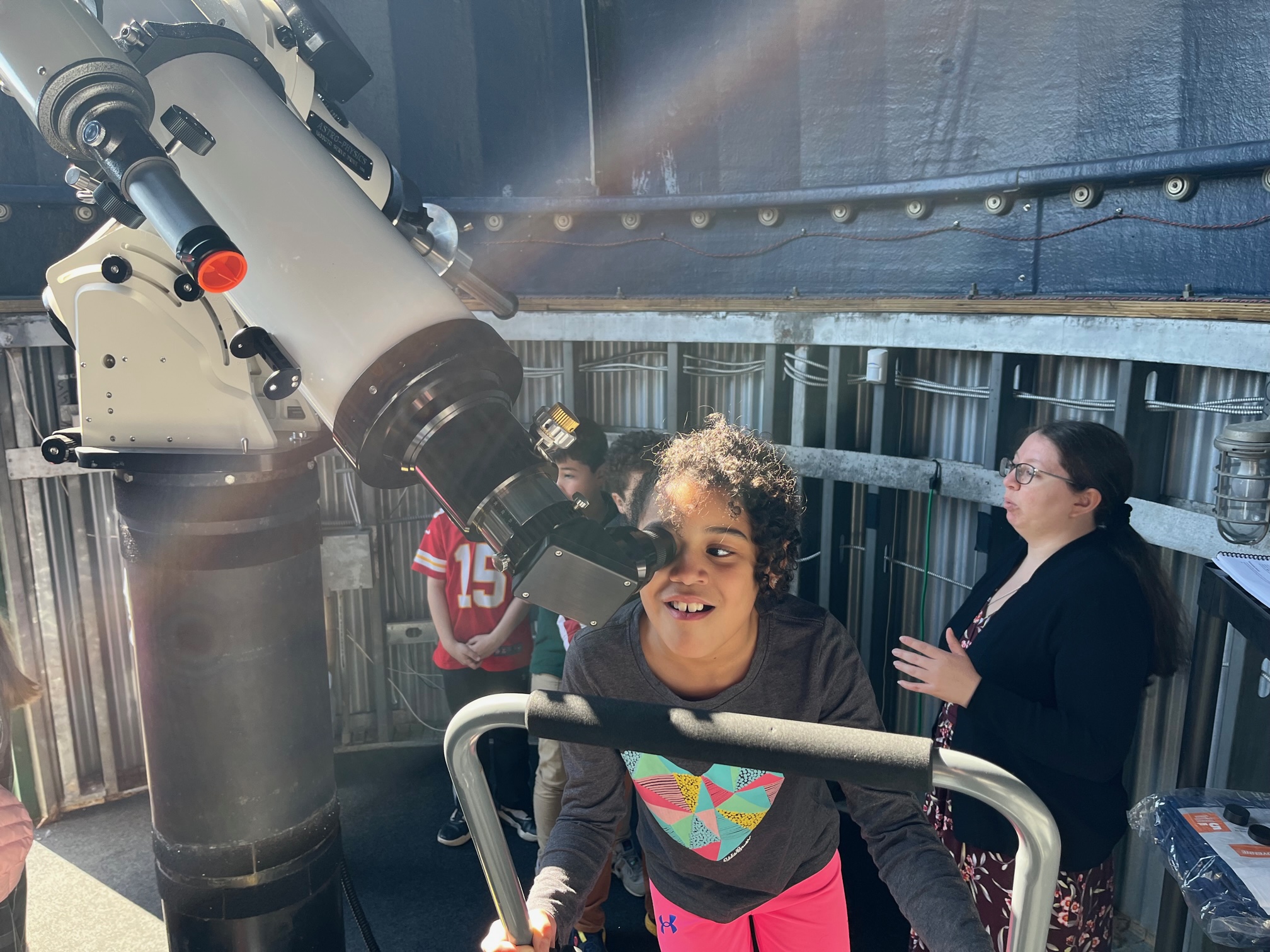 A third-grade student looks into the telescope at the Gould Observatory.