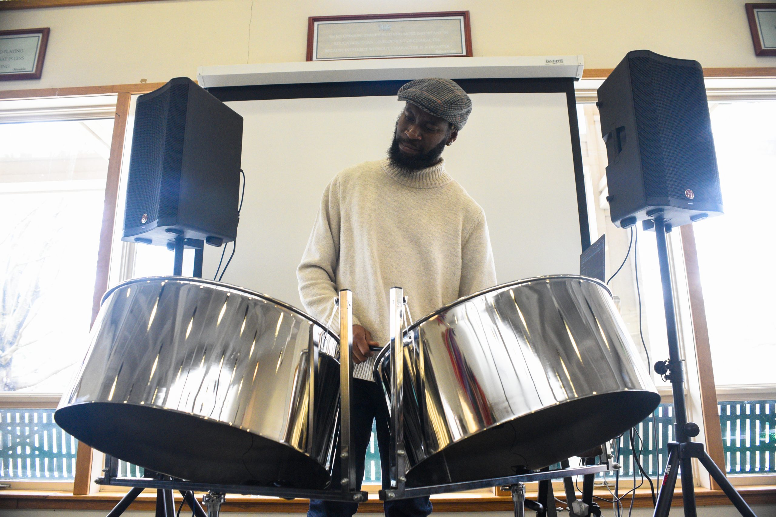 Sherwin Thwaites, a steelpan educator and musician, plans the instrument during the Upper School's lunch in February 2024.