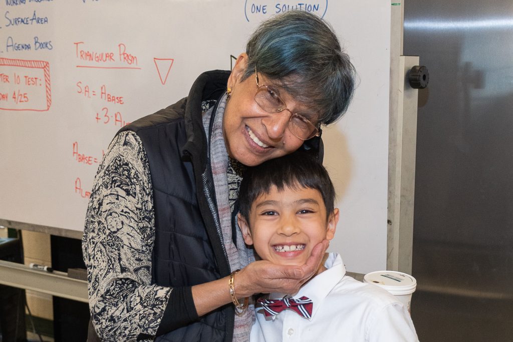 A child in a bow tie poses with his grandmother.