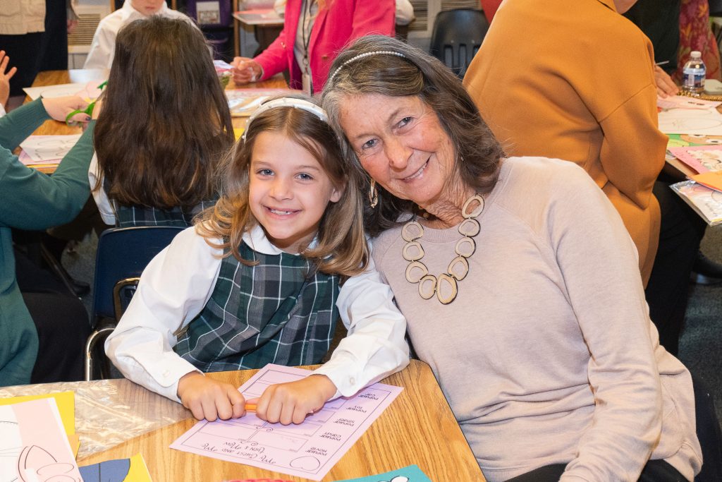 A grandmother and granddaughter pose for a photo.